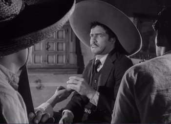 Movie still from “Viva Zapata!” (1952), directed by Elia Kazan – A black and white photo of a man wearing a large hat; Medium shot, Over the shoulder angle