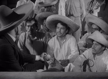 Movie still from “Viva Zapata!” (1952), directed by Elia Kazan – A group of men sitting next to each other wearing sombreros; Medium shot, High angle