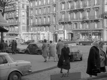 Movie still from “My Life to Live” (1962), directed by Jean-Luc Godard – An old black and white photo of people walking on the street; Extreme Wide shot, High angle