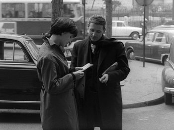 Movie still from “My Life to Live” (1962), directed by Jean-Luc Godard – Two women standing next to each other on the sidewalk; Medium shot, High angle
