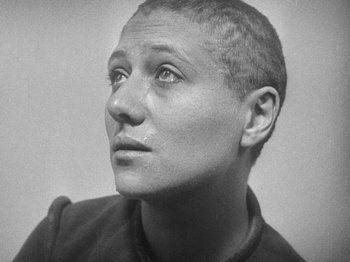 Movie still from “My Life to Live” (1962), directed by Jean-Luc Godard – A person with a shaved head; Close Up shot, High angle