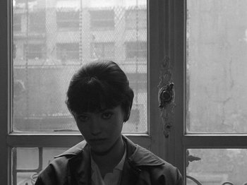 Movie still from “My Life to Live” (1962), directed by Jean-Luc Godard – A woman sitting in front of an open window; Close Up shot, High angle