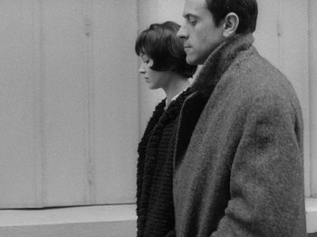Movie still from “My Life to Live” (1962), directed by Jean-Luc Godard – A man and a woman standing next to each other; Medium shot, Low angle