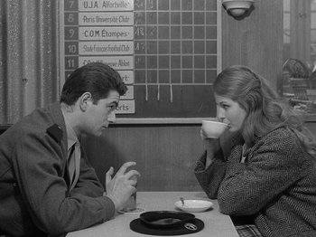 Movie still from “My Life to Live” (1962), directed by Jean-Luc Godard – A man and a woman sitting at a table drinking coffee; Medium shot, High angle