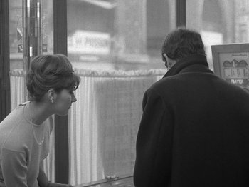 Movie still from “My Life to Live” (1962), directed by Jean-Luc Godard – A woman and a man looking out of a window; Medium shot, Over the shoulder angle