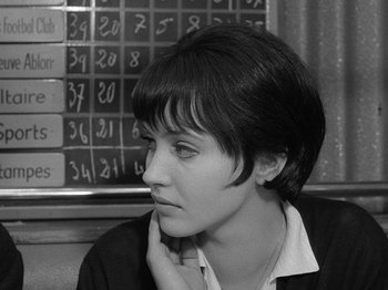 Movie still from “My Life to Live” (1962), directed by Jean-Luc Godard – Black and white photograph of a young woman in front of a wall of numbers; Close Up shot, High angle