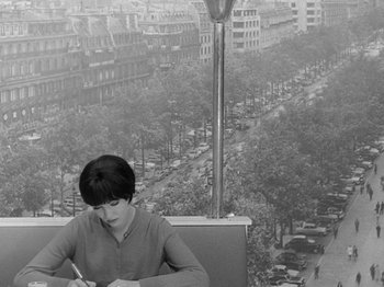 Movie still from “My Life to Live” (1962), directed by Jean-Luc Godard – A woman is writing on a paper on a balcony; Medium shot, High angle