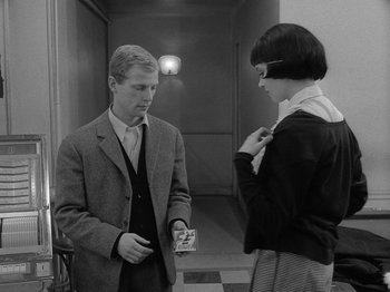 Movie still from “My Life to Live” (1962), directed by Jean-Luc Godard – A man and a woman standing next to each other in a hallway; Medium shot, High angle