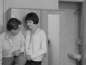 Movie still from “My Life to Live” (1962), directed by Jean-Luc Godard – A man and a woman sitting next to each other in a room; Medium shot, Over the shoulder angle