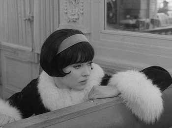 Movie still from “My Life to Live” (1962), directed by Jean-Luc Godard – A young woman in a black and white photo looking over her shoulder; Close Up shot, High angle