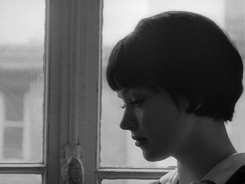 Movie still from “My Life to Live” (1962), directed by Jean-Luc Godard – A young woman looking out of a window; Close Up shot, Over the shoulder angle