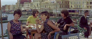 Movie still from “Von Ryan's Express” (1965), directed by Mark Robson – A group of people sitting at a table eating food; Medium shot, High angle