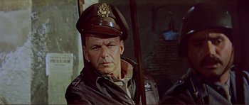 Movie still from “Von Ryan's Express” (1965), directed by Mark Robson – An older man wearing a military uniform and a hat; Close Up shot, Low angle