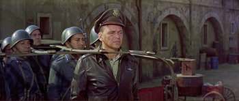 Movie still from “Von Ryan's Express” (1965), directed by Mark Robson – A man in a military uniform with a rifle in his hand; Medium shot, Low angle
