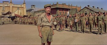 Movie still from “Von Ryan's Express” (1965), directed by Mark Robson – An old man standing in front of a group of soldiers; Wide shot, Low angle
