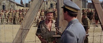 Movie still from “Von Ryan's Express” (1965), directed by Mark Robson – A man in a military uniform talking to another man in a uniform; Medium shot, Over the shoulder angle