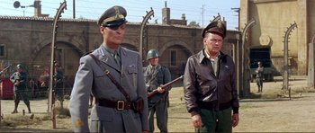 Movie still from “Von Ryan's Express” (1965), directed by Mark Robson – A group of men standing next to each other in uniform; Medium shot, Low angle