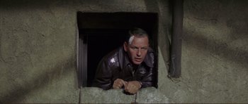 Movie still from “Von Ryan's Express” (1965), directed by Mark Robson – A man looking out of a window in a building; Close Up shot, Low angle