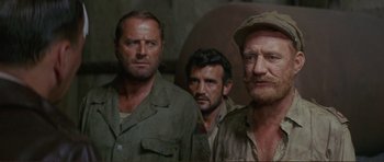 Movie still from “Von Ryan's Express” (1965), directed by Mark Robson – A group of men standing next to each other in a room; Close Up shot, Over the shoulder angle