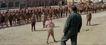 Movie still from “Von Ryan's Express” (1965), directed by Mark Robson – A group of men standing in front of each other; Wide shot, Over the shoulder angle