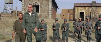 Movie still from “Von Ryan's Express” (1965), directed by Mark Robson – A group of men standing next to each other in uniform; Medium shot, Low angle