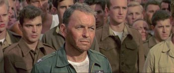 Movie still from “Von Ryan's Express” (1965), directed by Mark Robson – A group of men standing next to each other; Close Up shot, Over the shoulder angle