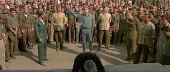 Movie still from “Von Ryan's Express” (1965), directed by Mark Robson – A group of men standing in front of one another; Wide shot, High angle