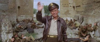 Movie still from “Von Ryan's Express” (1965), directed by Mark Robson – A man in a leather jacket and a hat waving; Medium shot, Low angle