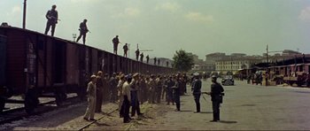 Movie still from “Von Ryan's Express” (1965), directed by Mark Robson – A group of people standing on top of a concrete wall; Extreme Wide shot, High angle