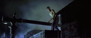 Movie still from “Von Ryan's Express” (1965), directed by Mark Robson – A man standing on a railing at night; Medium shot, Low angle