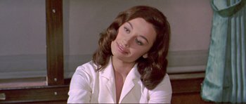 Movie still from “Von Ryan's Express” (1965), directed by Mark Robson – A woman in a white shirt is sitting down; Close Up shot, High angle