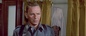 Movie still from “Von Ryan's Express” (1965), directed by Mark Robson – An older man wearing a uniform in front of a curtain; Close Up shot, Over the shoulder angle