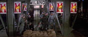 Movie still from “Von Ryan's Express” (1965), directed by Mark Robson – A group of men in uniforms are walking through a bridge; Wide shot, High angle