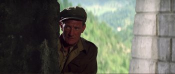 Movie still from “Von Ryan's Express” (1965), directed by Mark Robson – An older man wearing a hat standing next to a tree; Close Up shot, Low angle