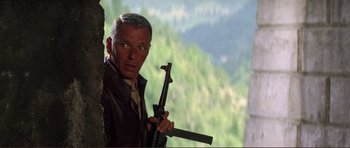 Movie still from “Von Ryan's Express” (1965), directed by Mark Robson – A man holding a gun in his hand; Medium shot, Low angle