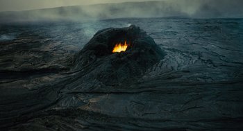 Movie still from “Voyage of Time” (2016), directed by Terrence Malick – A lava hole in the middle of a lava field; Extreme Wide shot, High angle