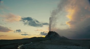 Movie still from “Voyage of Time” (2016), directed by Terrence Malick – A plume of smoke rises from a geyser in the distance; Extreme Wide shot, Low angle