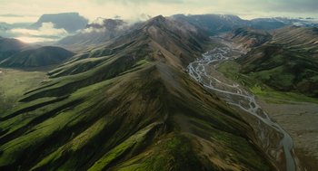 Movie still from “Voyage of Time” (2016), directed by Terrence Malick – An aerial view of a mountain with a winding road on it; Extreme Wide shot, High angle
