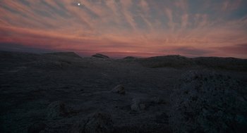 Movie still from “Voyage of Time” (2016), directed by Terrence Malick – The moon is setting in the sky over a desert landscape; Extreme Wide shot, High angle