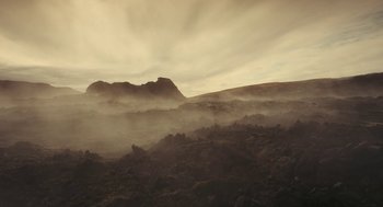 Movie still from “Voyage of Time” (2016), directed by Terrence Malick – A mountain range in the middle of the day with fog; Extreme Wide shot, High angle