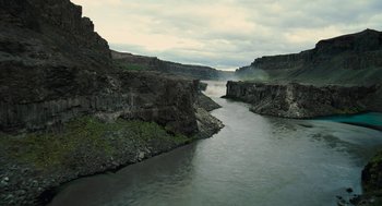 Movie still from “Voyage of Time” (2016), directed by Terrence Malick – A view of a river and a mountain range in the distance; Extreme Wide shot, High angle