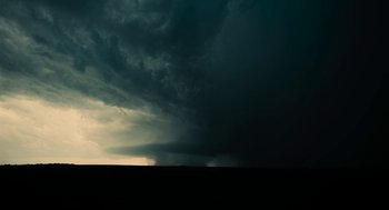 Movie still from “Voyage of Time” (2016), directed by Terrence Malick – A dark sky with a storm coming in from the horizon; Extreme Wide shot, Low angle