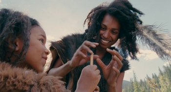 Movie still from “Voyage of Time” (2016), directed by Terrence Malick – Two women are playing with a wooden stick; Close Up shot, Over the shoulder angle