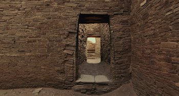Movie still from “Voyage of Time” (2016), directed by Terrence Malick – An open door in a stone building with a brick wall; Extreme Wide shot, Low angle