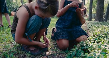 Movie still from “Voyage of Time” (2016), directed by Terrence Malick – A group of young girls sitting in the grass; Medium shot, High angle