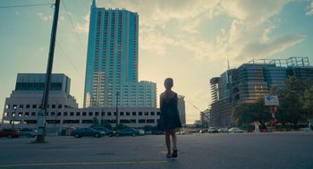 Movie still from “Voyage of Time” (2016), directed by Terrence Malick – A woman standing in the middle of the street; Extreme Wide shot, Low angle