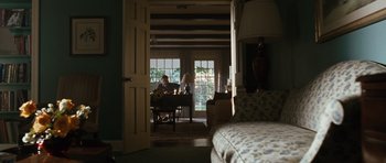 Movie still from “W.” (2008), directed by Oliver Stone – A person sitting at a desk in a room; Wide shot, High angle