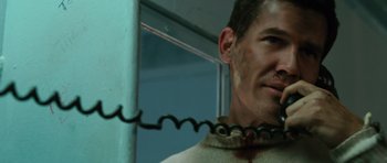 Movie still from “W.” (2008), directed by Oliver Stone – A person with a chain around his neck; Close Up shot, Low angle