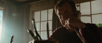 Movie still from “W.” (2008), directed by Oliver Stone – A man sitting in front of a table with a plate of food on top of it; Close Up shot, Low angle