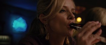 Movie still from “W.” (2008), directed by Oliver Stone – A woman with blonde hair is holding a pipe in her mouth; Close Up shot, Low angle